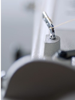 passing a thread trough the metal hook of a sewing machine