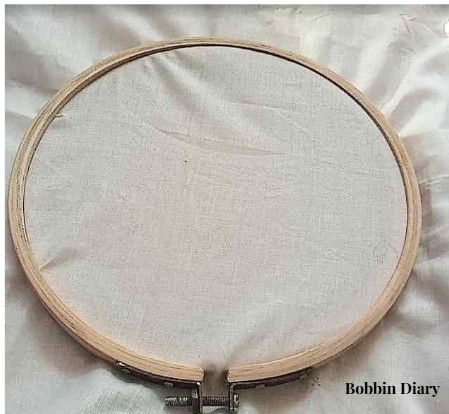 fitting fabric in the wooden embroidery hoop.